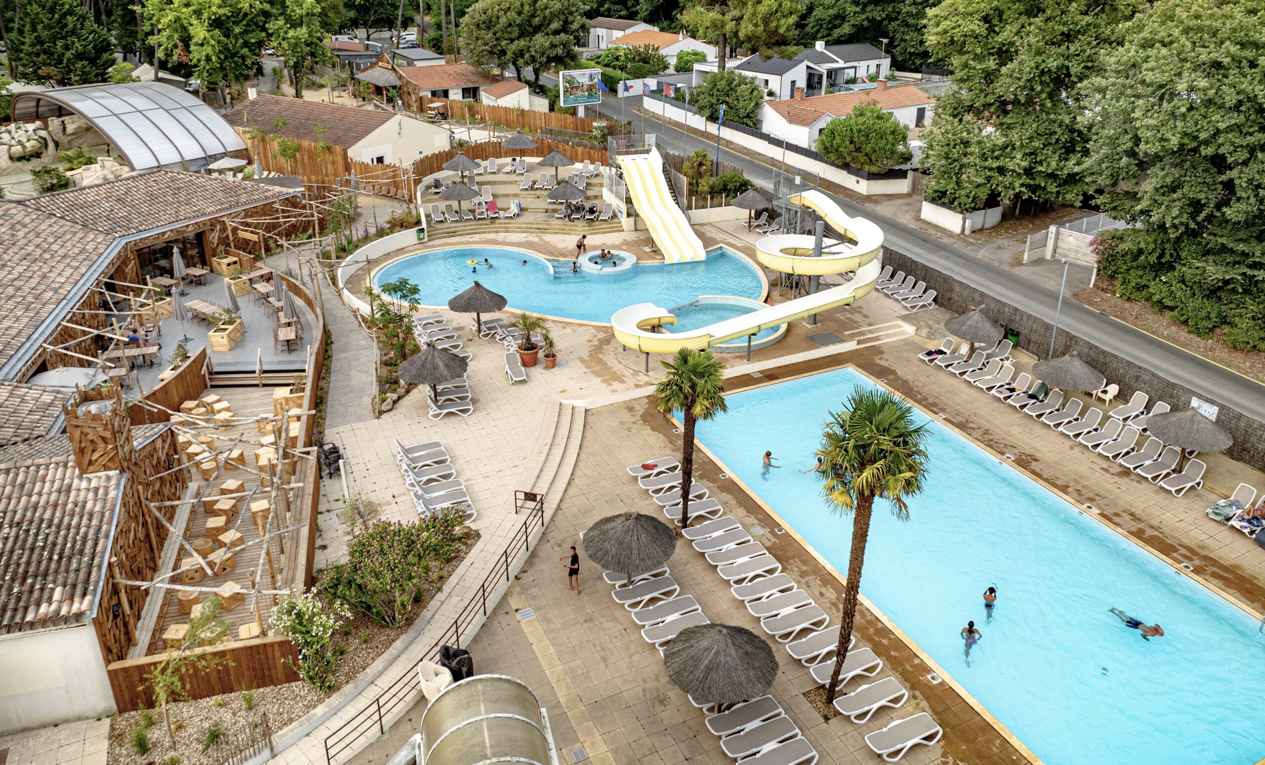 Vue aérienne du complexe aquatique avec piscines du camping Au Bois des Biches